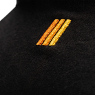 Close-up of a black garment with gold and bronze embroidered stripes.