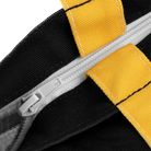 Close-up of a zipper on a black and yellow fabric background.