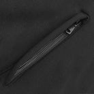 Close-up of a black zipper on a black background.