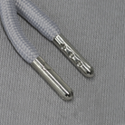 Silver aglets against a grey fabric background.