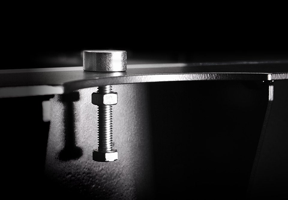 Close-up of a metal bracket with a bolt on a dark background.
