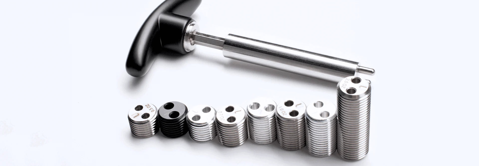 Metal tool with black handle and stack of metal weights