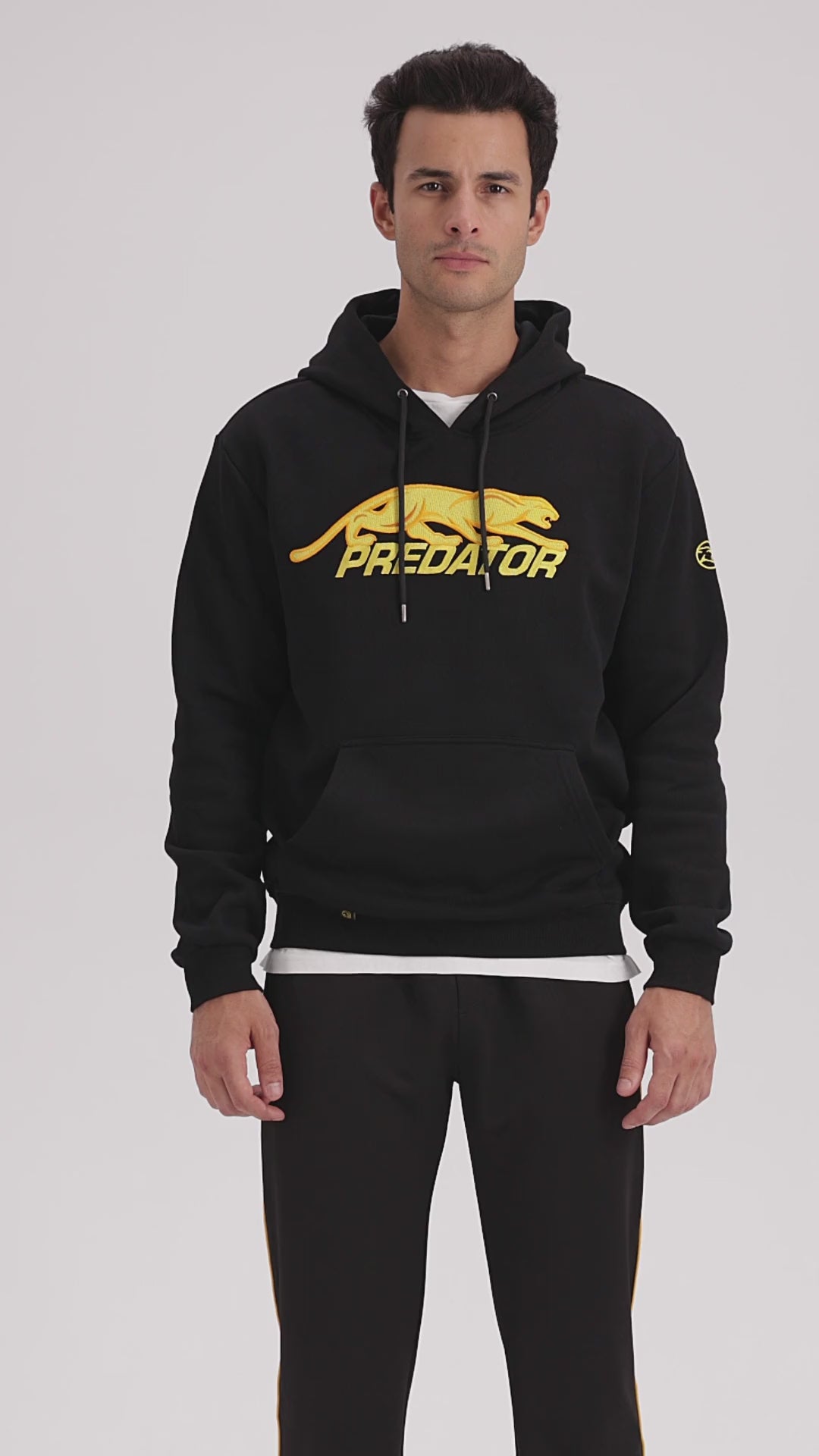 Video of a man wearing black hoodie with yellow Predator logo
