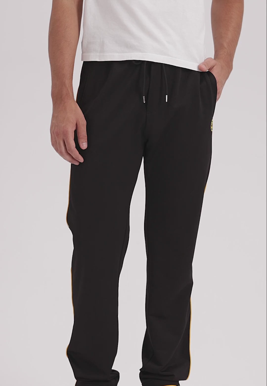 Video of a man wearing black pants with yellow stripe